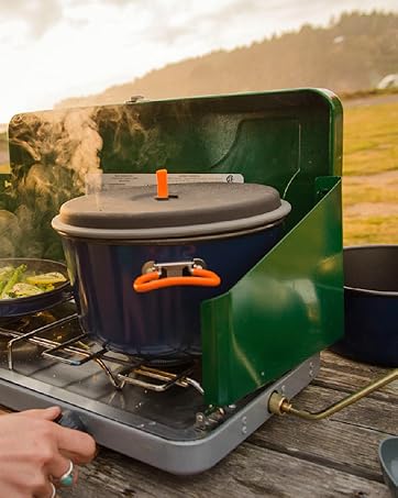 Photo shows food in GSI cookware being prepared on a camp stove outdoors.